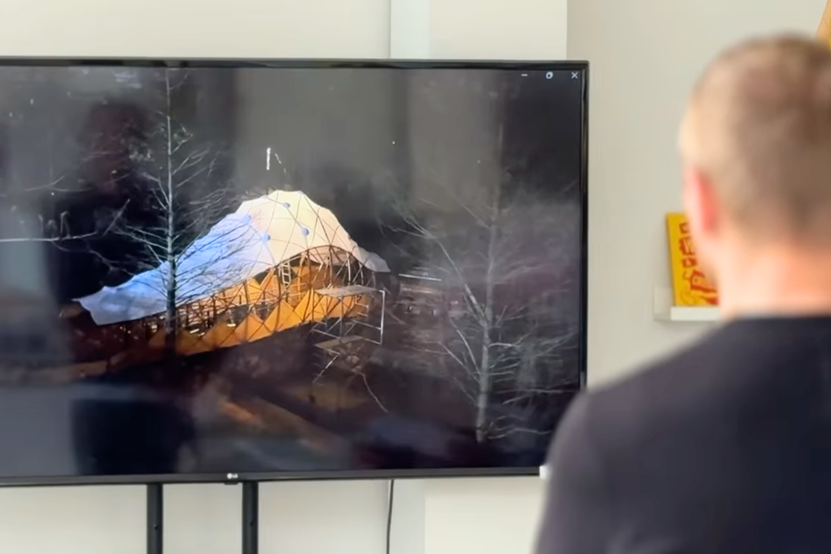 A visitor at the Tokyo exhibition watches a video documenting the making of Bridge Cocoon, a bamboo structure designed by NYCU Professor NK Kuo.
