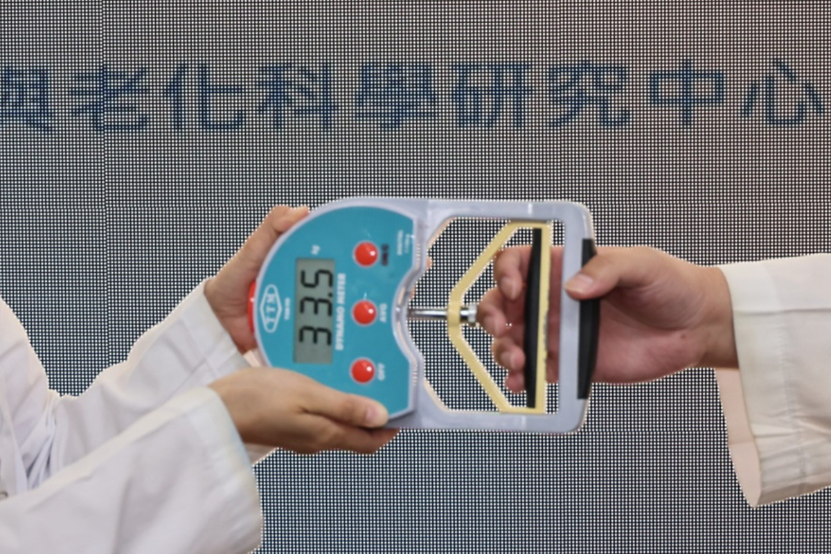 A clinician conducts a handgrip strength test, one of the key indicators used to assess muscle function in the updated Asian sarcopenia guidelines.