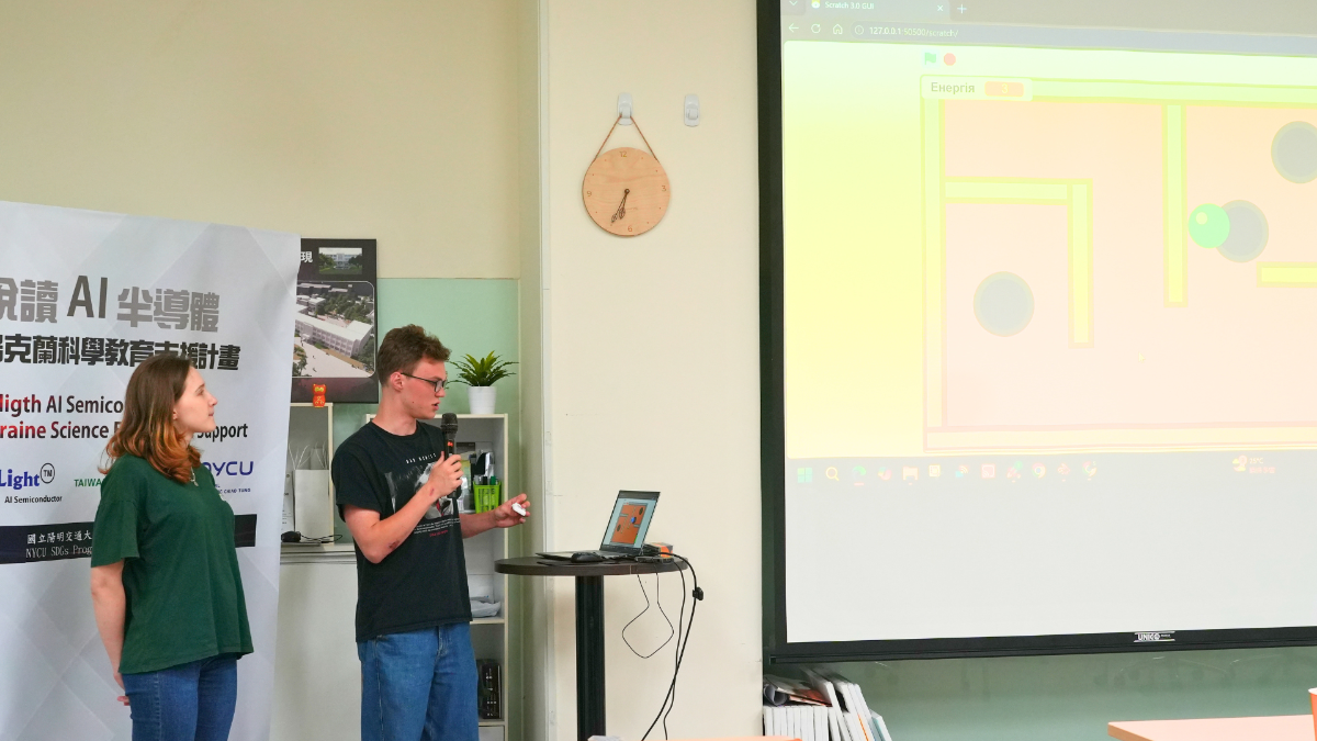 Ukrainian student Mariia Leontieva (left) and her classmate demonstrate the concept and gameplay behind their self-designed project using handheld sensors during the presentation session.